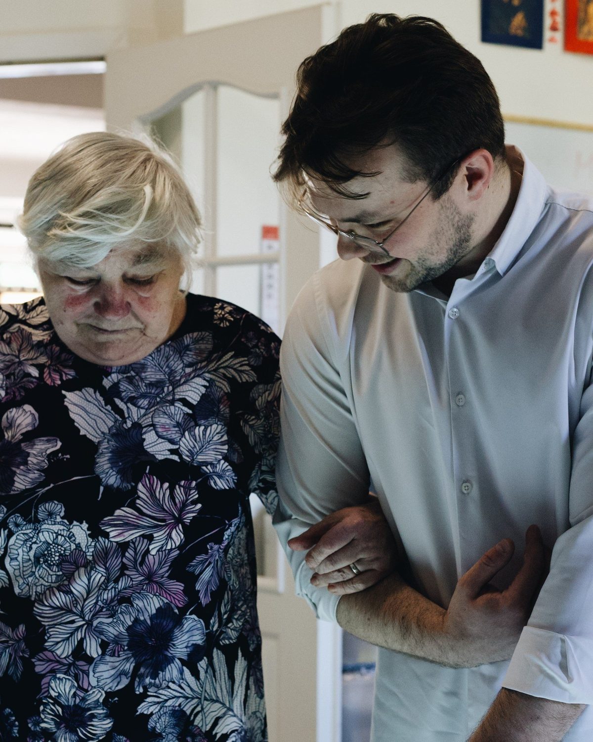 Opiekun wspiera seniorkę podczas aktywizacji